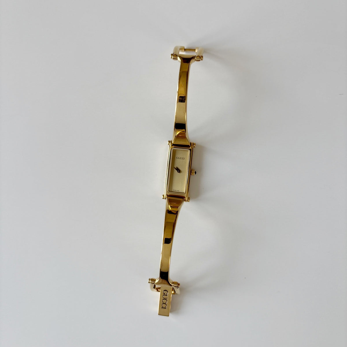 Gucci 1990s Rectangular Gold Dial Gold Plated Bangle Watch