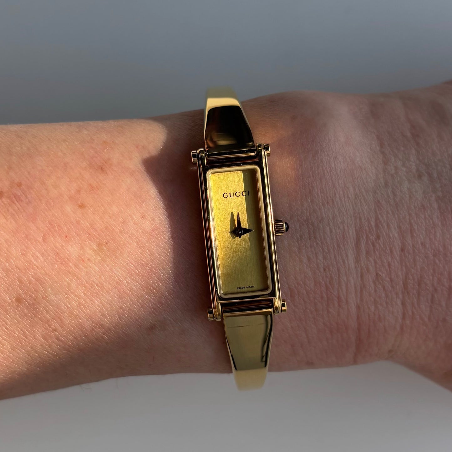 Gucci 1990s Rectangular Gold Dial Gold Plated Bangle Watch