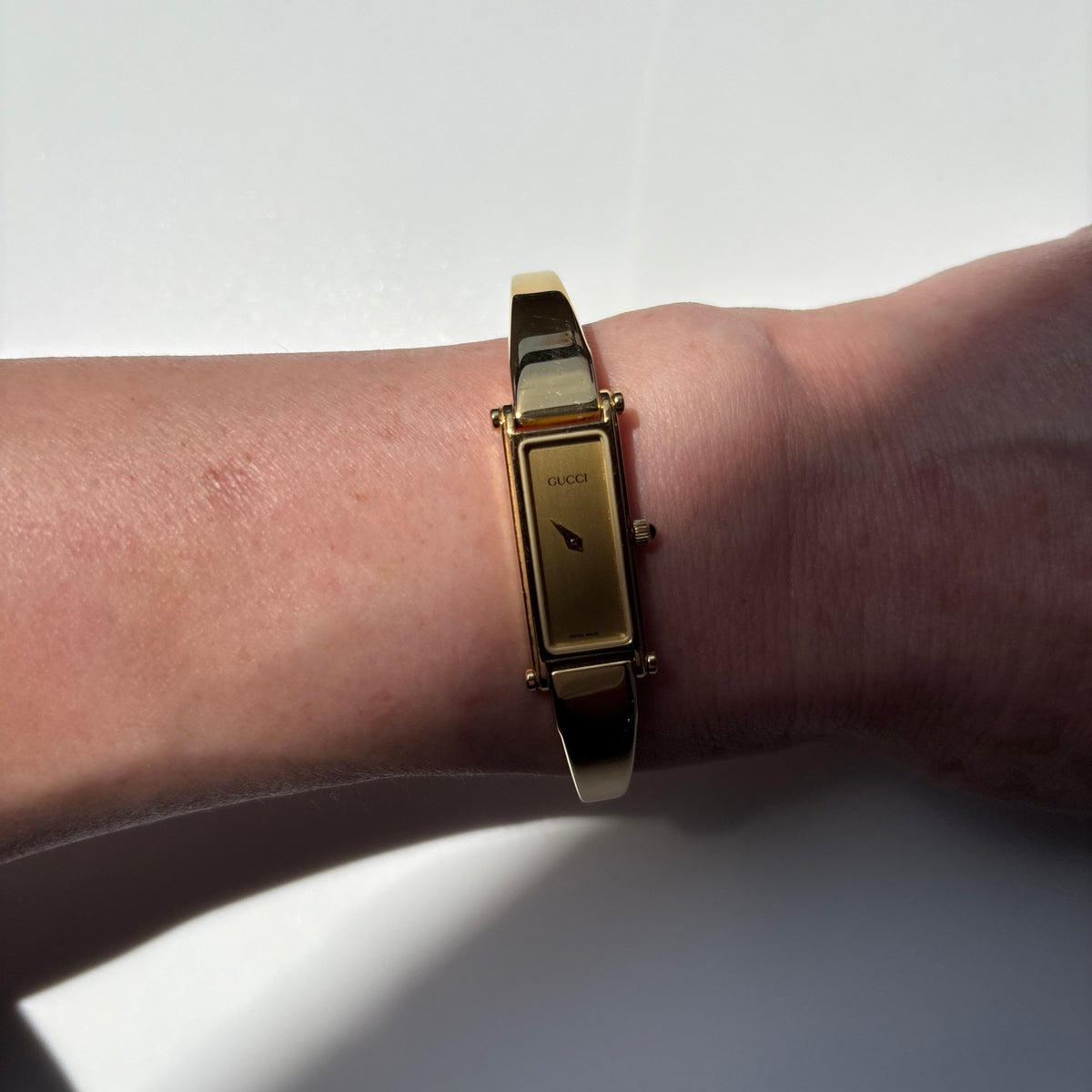 Gucci 1990s Rectangular Gold Dial Gold Plated Bangle Watch