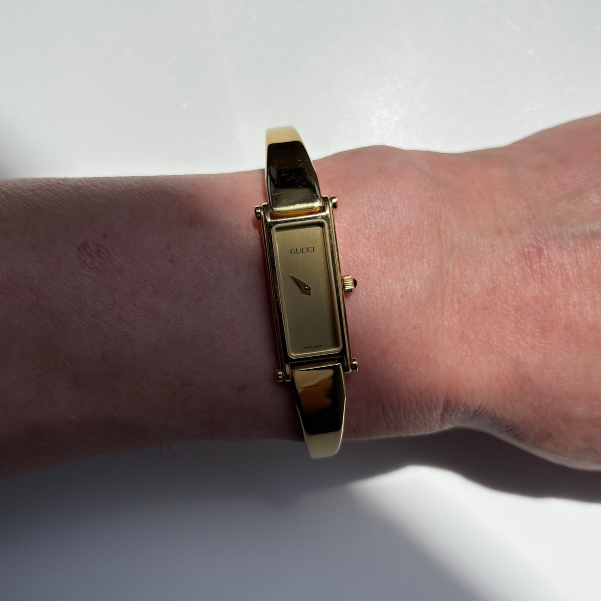 Gucci 1990s Rectangular Gold Dial Gold Plated Bangle Watch