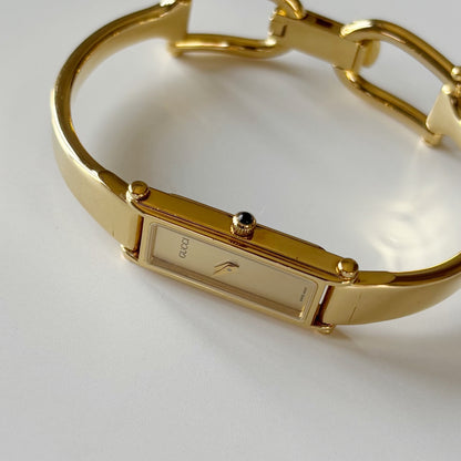 Gucci 1990s Rectangular Gold Dial Gold Plated Bangle Watch