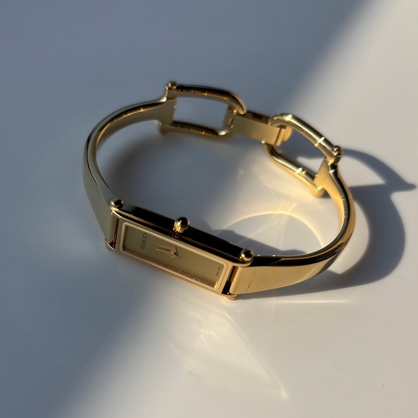 Gucci 1990s Rectangular Gold Dial Gold Plated Bangle Watch